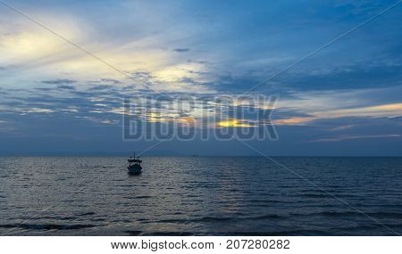 Small fishing boat off the Cambodian coast at sunset