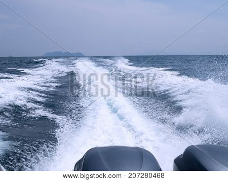 Trace tail of ferry speed boat on surface sea water. White wave view behind speed boat. Travel concept.