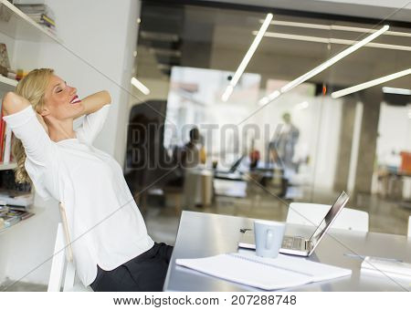 Businesswoman In The Office Taking A Break And Doing A Neck Exercise