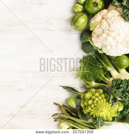 Above view, table top green vegetables and fruits on the white wooden table, copy space for text on the left, horizontal, top view, selective focus