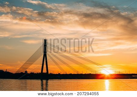 Riga, Latvia. Scenic View Of Vansu Cable-Stayed Bridge Over The Daugava River, Western Dvina In Bright Sunset Or Sunrise Time