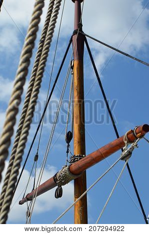 vertical image of ship mast with blue sky background