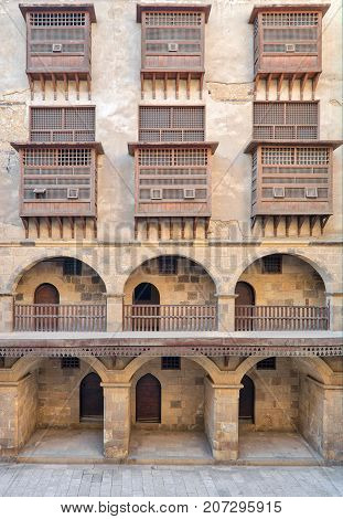 Facade of caravansary (Wikala) of Bazaraa with vaulted arcades and windows covered by interleaved wooden grids (mashrabiyya) suited in Tombakshia street Al Gamalia district Medieval Cairo Egypt
