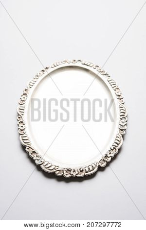 Stock photo of empty or blank silverware or oval shape plate with decorative border, isolated over white background, selective focus