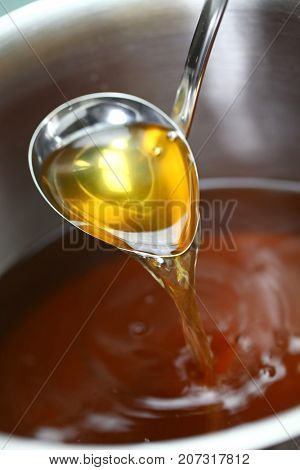 making chicken consomme soup in a pot