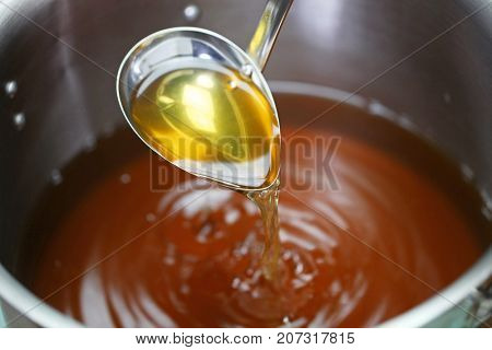 making chicken consomme soup in a pot