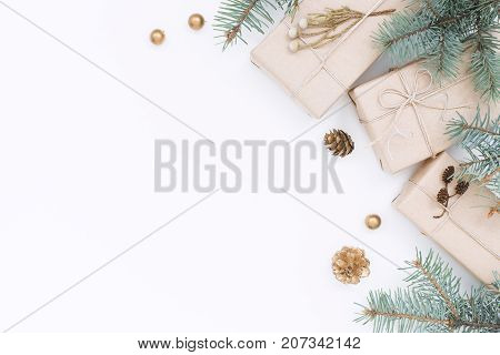 Three gift boxes Christmas decorations spruce branches and pine cones on white background. Top view holiday composition.