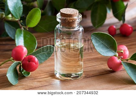 A Bottle Of Wintergreen Essential Oil On A Wooden Background