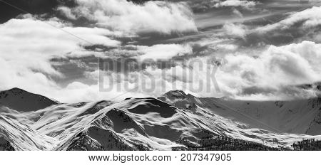 Black And White Panoramic View On Snow Sunlight Mountains And Cloudy Sky In Sun Evening
