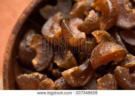 Ayurvedic Amla Candy, which is dried and salty-sweet or chatpata in taste and digestive. Served in a wooden bowl, selective focus