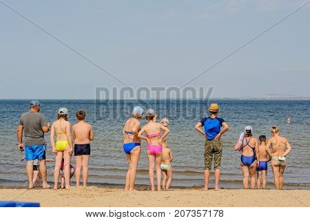 People Standing On Sand Near Sea