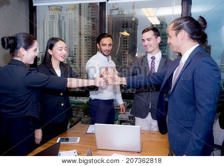 Portrait of happy business partners with smiles and geture of teamwork.