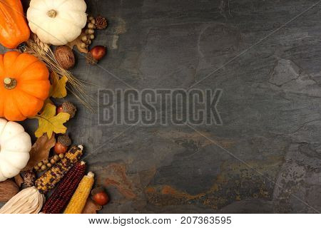 Autumn Harvest Side Border With Pumpkins, Leaves And Nuts Over A Slate Stone Background
