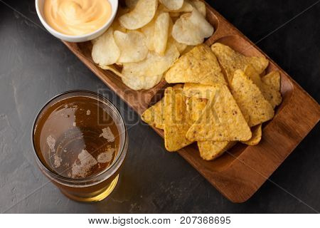 Beer In Glasses Closeup On The Concrete Table. Beer And Snacks Are Chips And Nachos With Cheese Souc