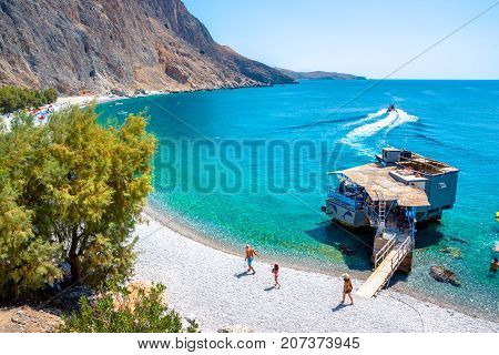 Glyka Nera beach (Sweet Water or Fresh Water). View of the remote and famous Sweet Water Beach in south Crete, with its unique tavern on the rock inside sea. This is a nudist beach on July 30, 2017.