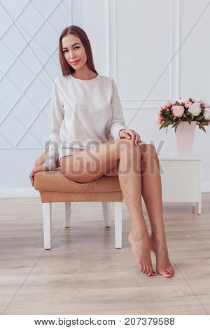 Sexy girl in a gray sweatshirt and panties. Mock-up.