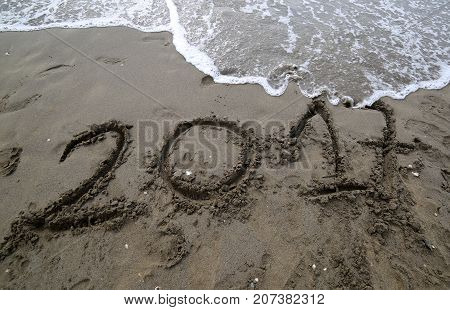 Text In The Year 2017 On The Sand Of The Sea Waiting To Be Cance
