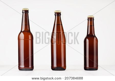 Collection brown beer bottles 500ml and 330ml mock up. Template for advertising design branding identity on white wood table.