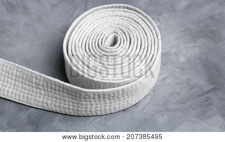 White karate belt on grey background