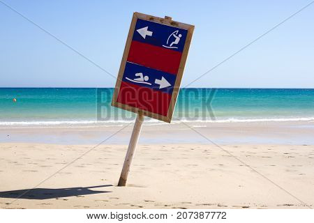 Wooden shield dug into the sand. Way to swim and wind surfing