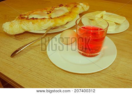 Adjarian khachapuri on a on a plate. Open pie with cheese in the shape of the boat. Delicious homemade khachapuri in Adjarian - Retro color