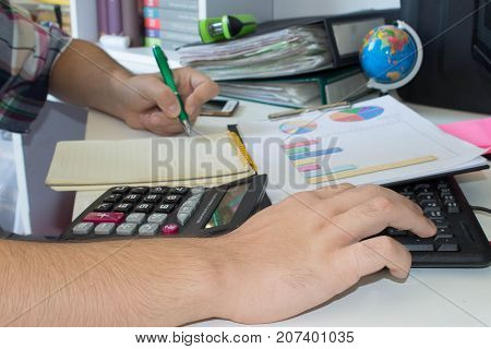 Businessman with computer at the deskdiscussing the charts and graphs showing the results of their successful teamwork. businessman working at a computer hands closeup