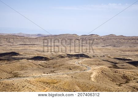 Large crater Ha-Makhtesh Ha-Gadol near Yeruham and the road leading to the colored sands (Israel)