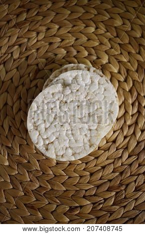 White flat round rice crackers on whicker place mat background.