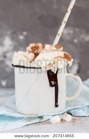 christmas background: cocoa with cream and cinnamon on a concrete background