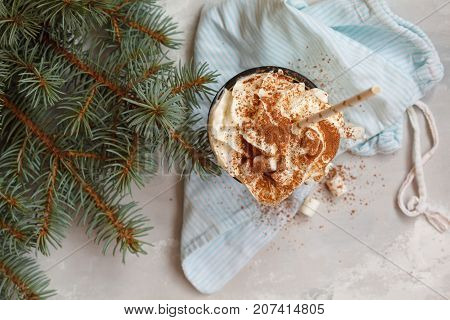 christmas background: cocoa with cream and cinnamon on a concrete background top view