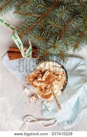 christmas background: cocoa with cream and cinnamon on a concrete background top view