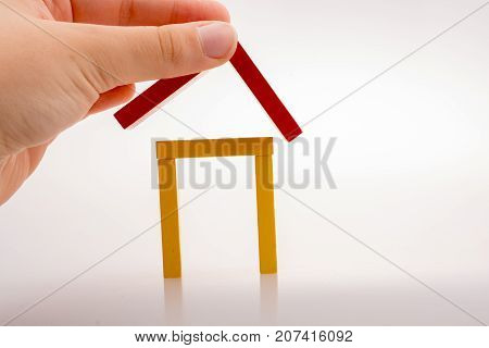 Hand holding domino pieces forming a house shape