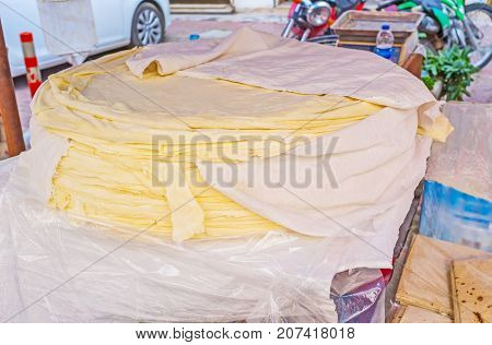 The thin sheets of traditional Turkish cheese in Friday Muratpasa outdoor market Antalya Turkey.
