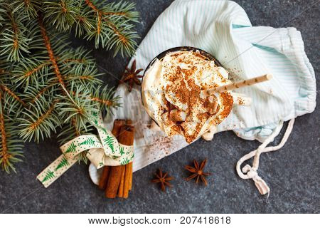 christmas background: cocoa with cream and cinnamon on a concrete background top view