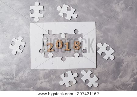 New Year Concept 2018. Jigsaw Puzzle On Grey Concrete Background.