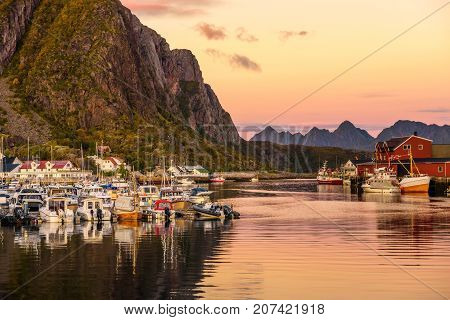 Many yachts anchored at the Marina of Svolvaer on Lofoten islands in Norway. This harbor is in the mountains and was photographed at sunset.