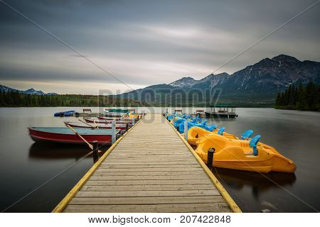Boats on a jetty on the Pyramid Lake in Jasper National Park, Alberta, Canada. Long exposure.