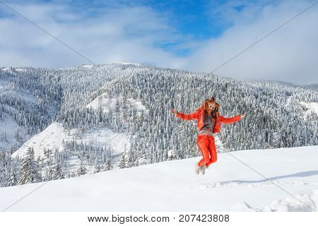 A young happy girl enjoys beauty of winter landscape near beautiful lake Amut in taiga hills on Far East of Russia in early october.