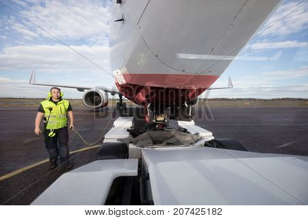 Ground Worker Standing By Aircraft With Communication Cable On R