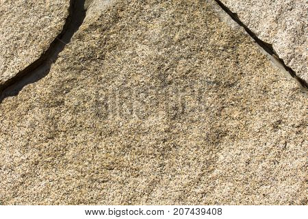 The granite surface of the wall is light brown in color.