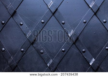 Slashed black painted iron door with steel stripes.