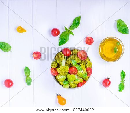 Top View Salad Bowl With Cherry Tomatoes, Boiled Broccoli, Basil And Fresh Ingredients On The White