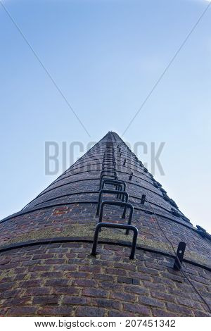 Bottom view of the old brick high pipe of the old factory.
