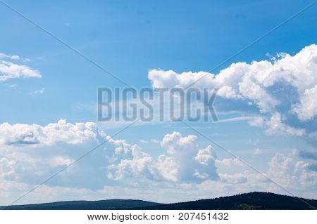 Clouds over forest hills located very far away