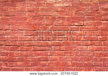 An old brick masonry wall of a warehouse made of red brick.