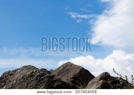 Clouds in the background with rocks rocks in the foreground.
