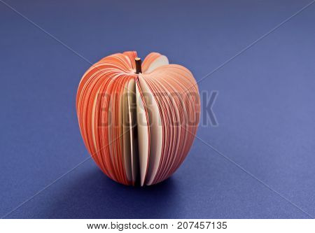 Fake Apple from paper on the purple violet background. Office notes diet concept close up soft focus