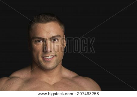 Sportmen Looks Into the Camera and Smiling on Black Background