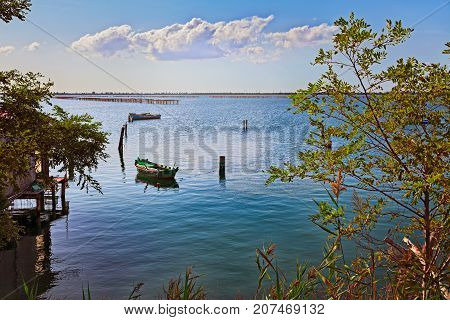 Porto Tolle, Rovigo, Veneto, Italy: marine landscape of the Adriatic sea in the Po Delta Park with fishing boats and wooden poles for mussels farming