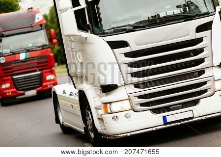 Trucks being driven on road picking up goods